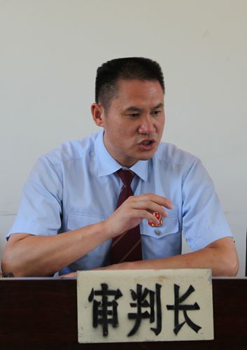 图为审判长李学宏向旁听群众宣传《老年人权益保障法》等内容